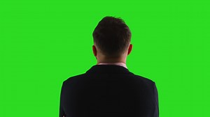 Free stock video - Close up studio rear view shot of male teacher or businessman facing away from camera towards green screen