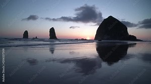 Haystack Rock, Cannon Beach Sunset 4K. UHD. Sunset at Haystack Rock in Cannon Beach, Oregon as the surf washes up onto the beach. United States. 4K, UHD.