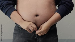 overweight man closeup of belly side view. put up shirt and pinch and clap a belly
