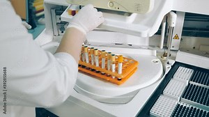 Laboratory assistant lays the samples in test tubes in the apparatus for biochemical analysis of blood. Work in the laboratory of blood research