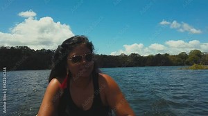 A woman sitting in a dug canoe on her way to visit the the Embera tribal community in the rainforest of Panama,
