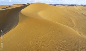 Rub' al Khali, aka Empty Quarter desert, Arabian Peninsula. Flying over curve shaped sand dunes during hot summer weather. Aerial shot, 4K