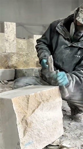 Carving large stone blocks with a hammer and chisel before lifting them using a heavy crane system