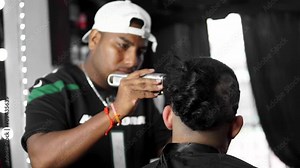 Hispanic barber man cutting a hair of male client.