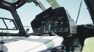 Dolly out shot of helicopter cockpit, pilot and passenger seats, control panel with different command buttons and joysticks for navigation, helicopter cockpit interior view concept