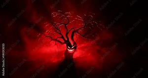 Silhouette of scary Halloween tree with horror face on dark foggy toned background with moon on back side. Scary horror tree with zombie and monster demon faces. Stock Video