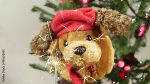 The hand puppet doggie congratulates Merry Christmas and New Year against the background of a Christmas tree