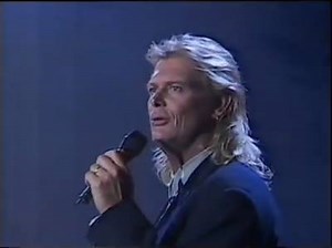 25 years ago John re-released a live version of "Please Don't Ask Me". Originally released in 1980, the version in this clip was released as part of the live Full House album in 1991. | John Farnham