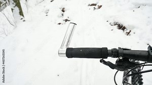 Bike riding in snow. The front wheel of mountain bike turning in snow and suspension fork eliminate vibrations. Lost path under snowdrift by forest singletrack. Slow motion.