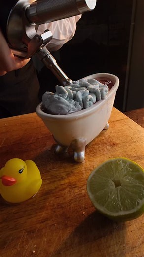 The Duckie 🐥🛁 Rub-a-dub-dub, there’s tequila in this tub. Barrel-aged Maestro Dobel Diamante meets blueberry and blue curaçao, served in a mini bathtub with bubble bath foam and a rubber duckie garnish — our nod to the Krewe of Muses and their legendary floats. Watch Head Bartender Ember Siegmund bring it to life. Now part of the Brennan’s Carnival Cocktails collection. | Brennan's Restaurant