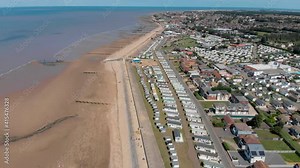 Aerial footage of the British seaside town of Hunstanton Norfolk, showing the caravans and camp sites by the ocean front with the long sandy beaches on the beach front