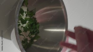 Sprinkle fresh parsley into mixing bowl with yogurt. Vertical 4K