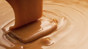 Download Pouring melted caramel, closeup food shot. for free