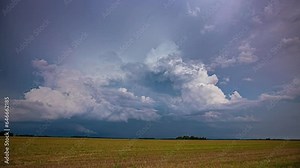 Storm forming above agriculture fields, vibrant dark clouds, time lapse view