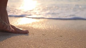 Barefoot Woman Foot Walking on Sand on Beach at Sunset