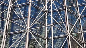 Modern architecture abstract - steel pipes as frame for glass interior, roof or exterior construction of a building. Geometric structure as urban background featuring metal skeleton and blue sky
