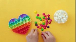 Use the popular pop it toy as a chocolate mold. White chocolate and colorful candies. DIY concept. Step-by-step photo instructions. Step 1.