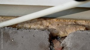 DIY. Filling with mounting foam between the window space for energy saving. Keep your home warmer through insulation. Close up