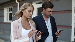 Free stock video - Close up view of couple using phones on the street