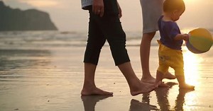 Asian family walking on the beach together