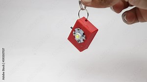 Flashlight or small torchlight made from 3d printing technology held in hand hanging as a key chain. Survival small flash lamp