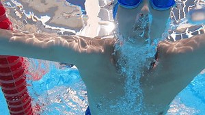 Shirtless man swimming underwater. Dedicated male athlete doing training during weekend. He is performing aquatic sport during summer.