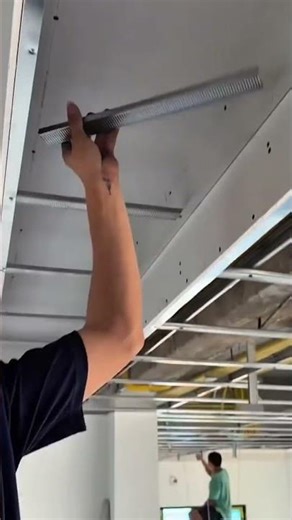 Cutting the ceiling support metal using pliers carefully to fit it securely and properly in place.