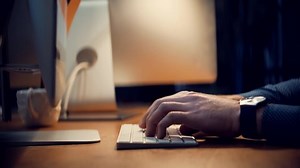 Creative Man With Computer Working At Open Space Room On Night.Male Hand Typing On Computer Keyboard.Overtime Work In Office.Man Typing On Keyboard At Night.Man Working In Office And Writing Message.