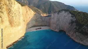 Cinematic wide drone shot of Navagio Beach. Rotating aerial shot revealing the serene beauty of Shipwreck Beach and its towering bluffs in Zakynthos.