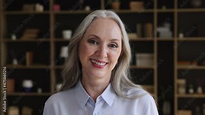 Headshot portrait of positive grey haired senior woman with beautiful smile white teeth healthy skin. Confident middle aged lady teacher leader boss pensioner retiree pose indoors laugh look at camera