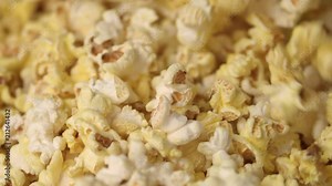 Mixing hot popcorn in heap. Close up of fresh popcorn flakes. Popping up pop corn. Process of popcorn production. Fresh corn flakes. Cinema food concept. Pop corn background