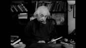 Theoretical Physicist Albert Einstein working at desk looking down...
