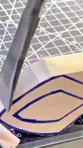 precision cutting of complex cardboard patterns using a sharp craft knife on a green cutting mat