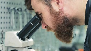 Diagnostics of diesel injectors under a microscope. The master examines the nozzle under a microscope to detect defects.