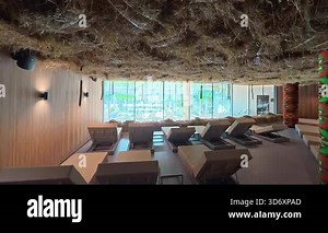 A relaxation room in a spa center with soft hay and comfortable lounge chairs creates a warm, calming atmosphere for rest.