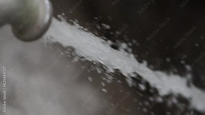 Detail of Water coming out and spraying from an old faucet slow motion
