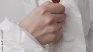 Laboratory worker or doctor zipping up hazmat or a biohazard protective suit before work with coronavirus, Covid-19, SARS-Cov-2 patients.