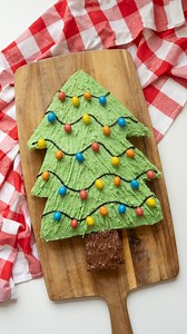 🎄 Christmas Tree Cake 🎄 Recipe below 👇🏻 I LOVE how the the M&Ms look like lights. It's such a simple way to make a cake look festive. I made a tree template from paper first but you could cut freehand if you feel confident too. 200g caster sugar 200g butter, softened 200g self raising flour 3 eggs 1 tsp vanilla extract 1 tsp baking powder 400g tub green buttercream 30g chocolate spread Black icing (25g icing, black icing and water) Crispy M&Ms Preheat the oven to 150°C and line a 29cm rectan