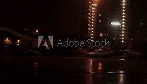 View through side window of railway railroad train. Night city with buildings. Lighting from street lamps and lanterns. Travel and tourism concept.
