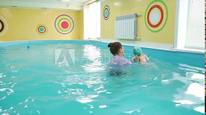 Little Baby Diving Underwater with Help of Swimming Coach in Slow Motion. Cute Little Boy Learning to Swim in a Paddling Pool. Healthy Lifestyle and Early Development Concept Stock Video