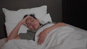 Woman feeling sad lying in bed alone trying to sleep thinking about problems