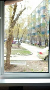 young woman washes windows unsafely on the first floor. Washing windows at home