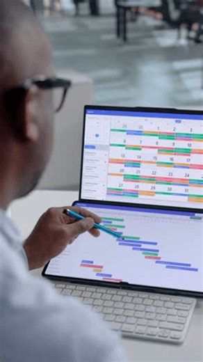 clip-4144177599-project-manager-plans-team-schedule-using-dual