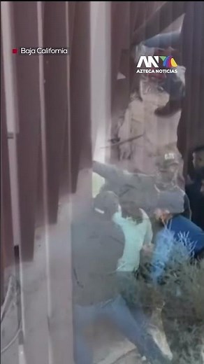 CUTTING THE WALL | Individuals cut a section of the border wall to allow migrants to pass through