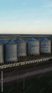 Grain elevator. Metal grain elevator in agricultural zone. Aerial vertical view. Agriculture storage for harvest. Grain silos on green nature background. Exterior of agricultural factory. Nobody.