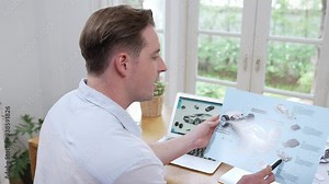 Car design engineer analyze car prototype for automobile business at home office. Automotive engineering designer carefully analyze, finding flaws and improvement for car design with laptop Fastidious