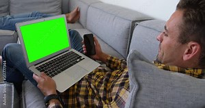 Young man using laptop in living room at home