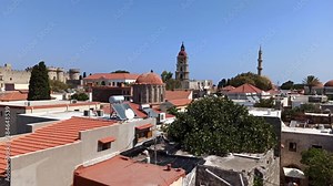 Rhodes, Greece - September 23, 2020: Pan shot of houses built in the Rodos city, medieval style greek architecture and castle against houses using solar panel