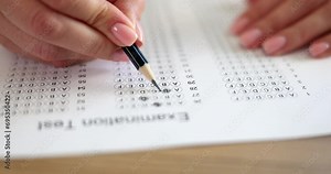 Woman hand holds pencil and marks answers to test. Hiring testing concept