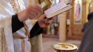 A priest in the church during the wedding ceremony consecrates gold wedding rings for the bride